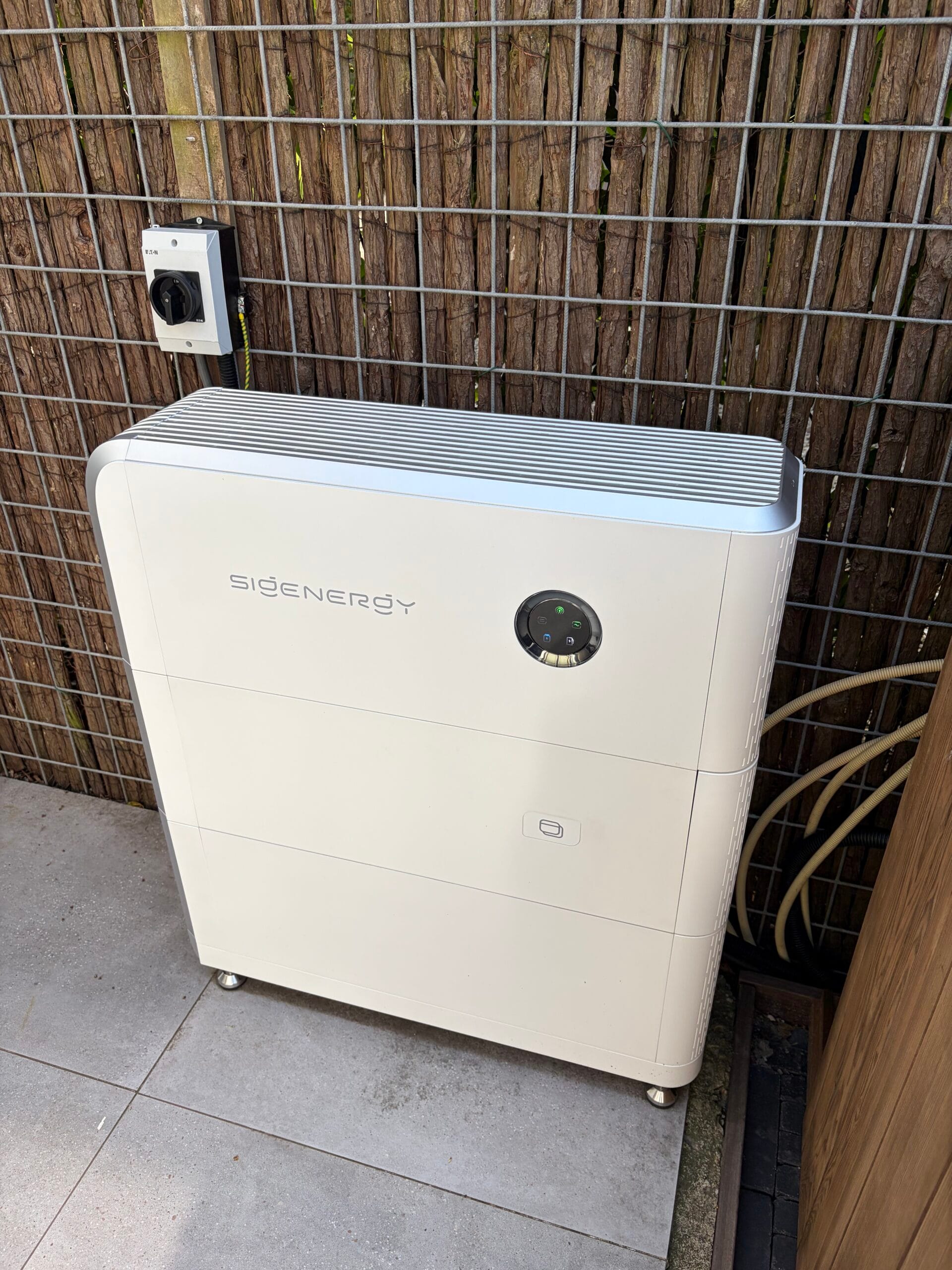 Thuisbatterij buiten geplaatst in de tuin bij een woning